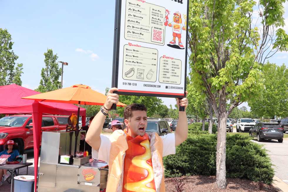 Cheesedogs cart with menu sign and team serving at a Triangle NC event
